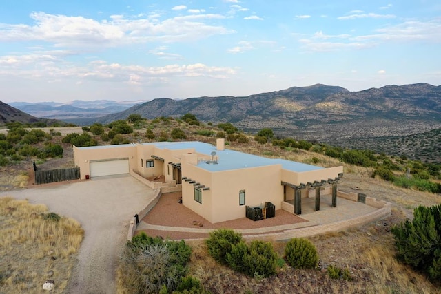 3 Dark Sky Dr, Alpine, TX 79830 - pueblo-style home with a mountain view, stucco siding, an attached garage, driveway, and a chimney