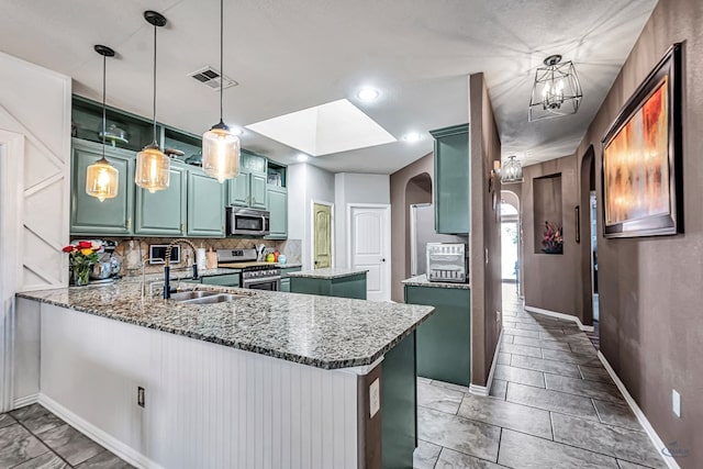 6411 Hall Of Fame, Midland, TX 79706 - kitchen with appliances with stainless steel finishes, a sink, arched walkways, baseboards, and tasteful backsplash