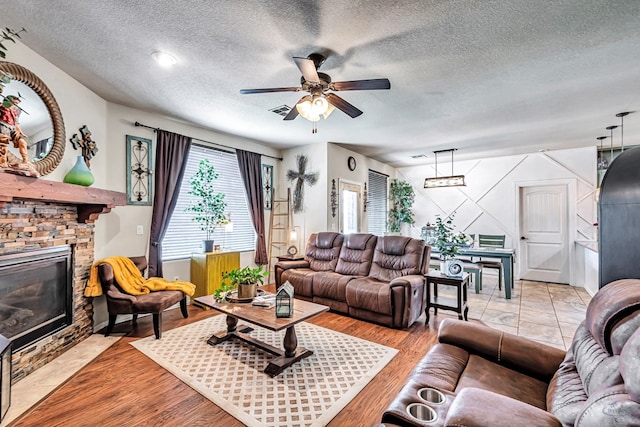 6411 Hall Of Fame, Midland, TX 79706 - living area with a fireplace, a ceiling fan, a textured ceiling, and light wood-type flooring