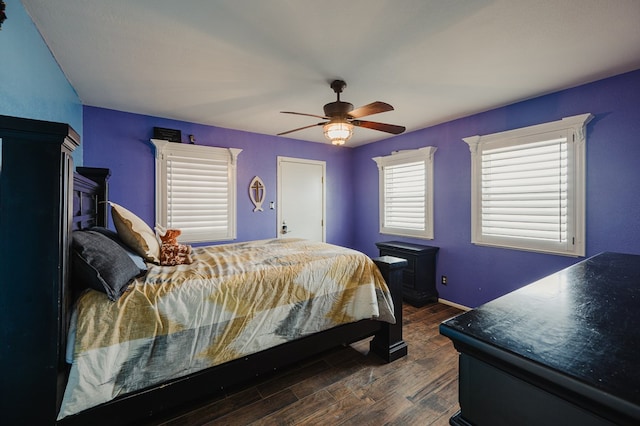3708 N Moss Ave, Odessa, TX 79764 - bedroom with dark wood-style flooring, a wood stove, ceiling fan, and baseboards