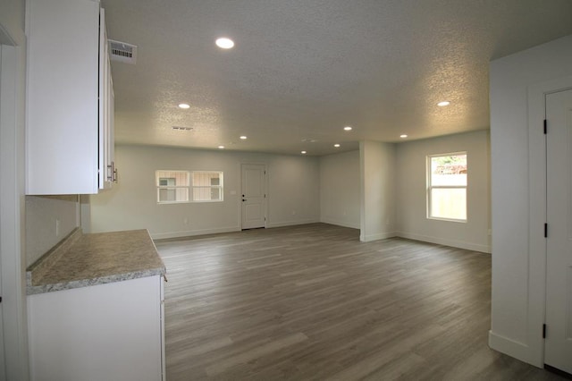 607 NW 11th St, Andrews, TX 79714 - unfurnished living room with a textured ceiling, wood finished floors, and recessed lighting