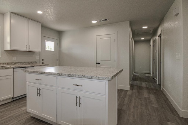 607 NW 11th St, Andrews, TX 79714 - kitchen featuring white dishwasher, dark wood finished floors, a textured ceiling, light countertops, and white cabinets
