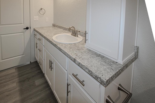 607 NW 11th St, Andrews, TX 79714 - bathroom with a textured wall, vanity, and wood finished floors