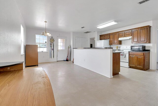 1206 Alameda Ave, Odessa, TX 79763 - kitchen with white range with electric cooktop, refrigerator, under cabinet range hood, black microwave, and a chandelier