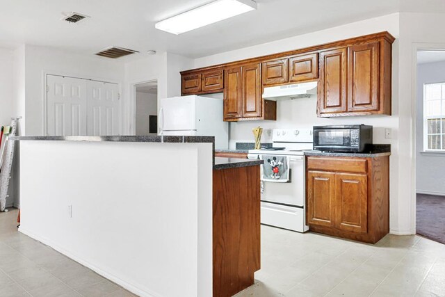 1206 Alameda Ave, Odessa, TX 79763 - kitchen with white appliances, under cabinet range hood, a kitchen island, brown cabinets, and dark countertops