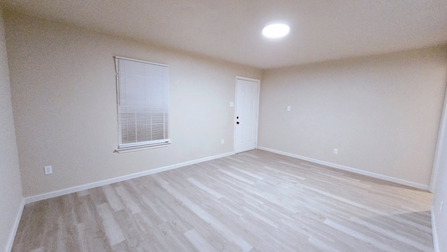 empty room with light wood-type flooring and baseboards