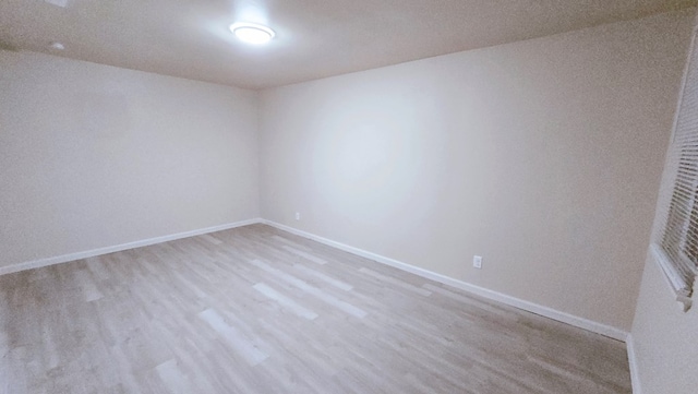 empty room with baseboards and light wood finished floors