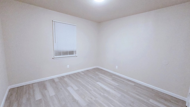 unfurnished room with baseboards and light wood-style floors