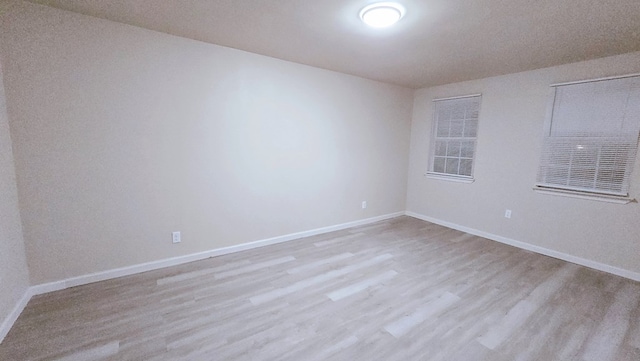 empty room featuring light wood-style flooring and baseboards