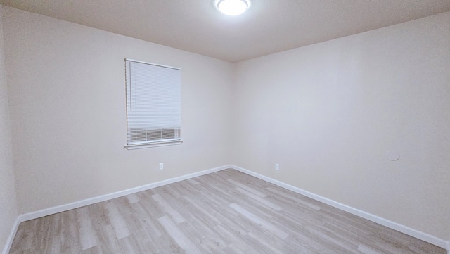 empty room with light wood finished floors and baseboards