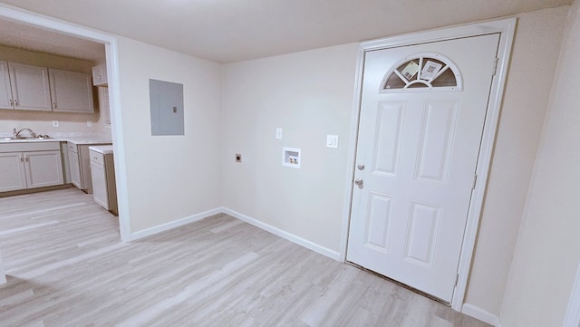 laundry room with light wood-style flooring, hookup for an electric dryer, washer hookup, a sink, and electric panel