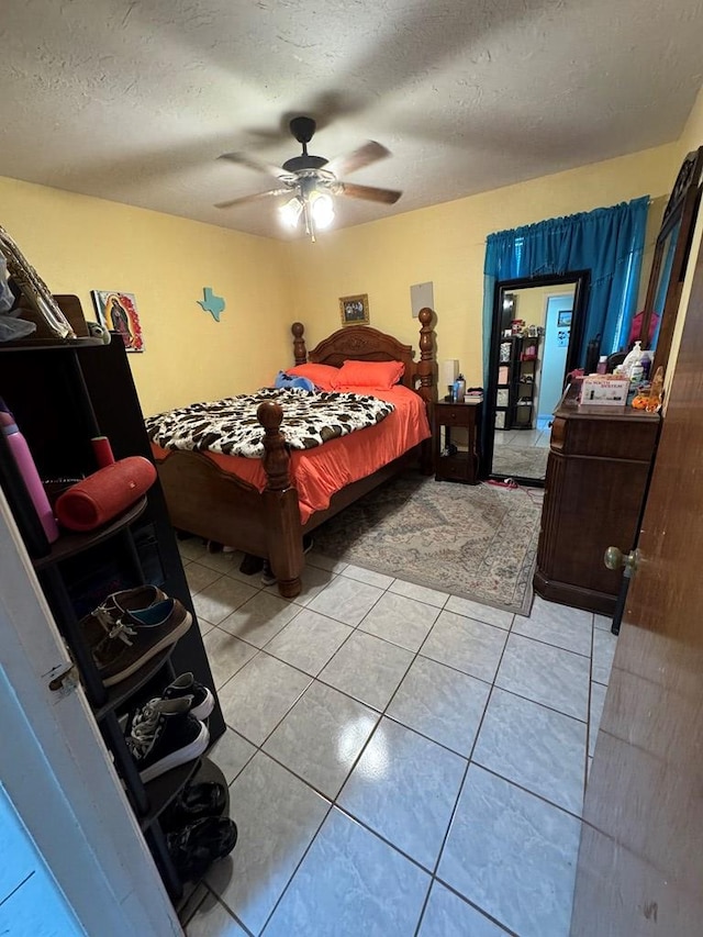 1044 Washington St, Kermit, TX 79745 - bedroom featuring light tile patterned floors, a textured ceiling, and ceiling fan