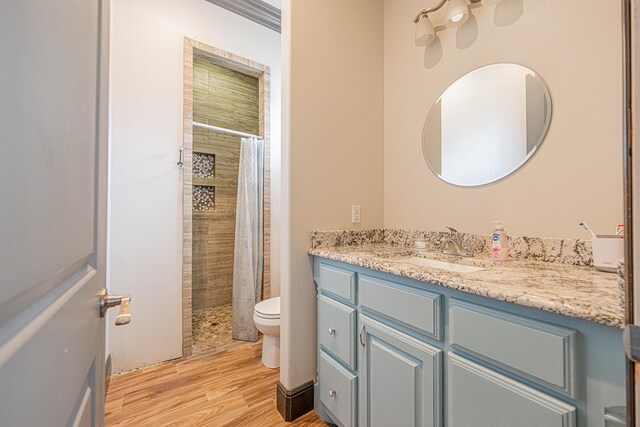14105 County Rd 122, Odessa, TX 79765 - bathroom featuring toilet, wood finished floors, tiled shower, and vanity
