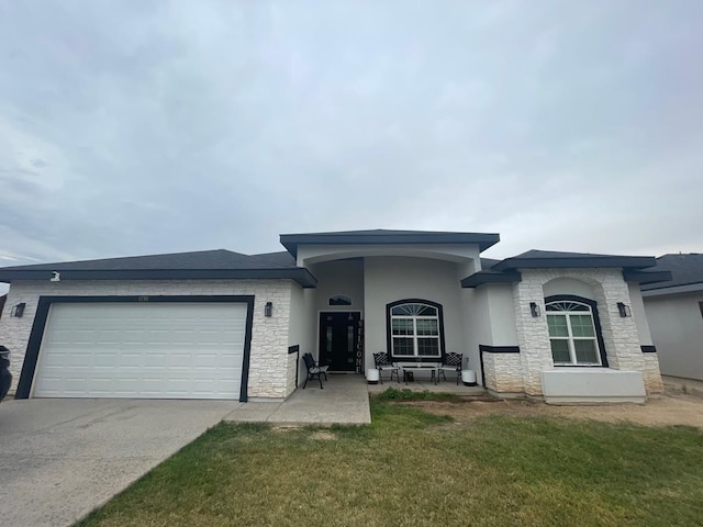 1710 W 4th St, Fort Stockton, TX 79735 - view of front of property with an attached garage, concrete driveway, a front lawn, and stone siding
