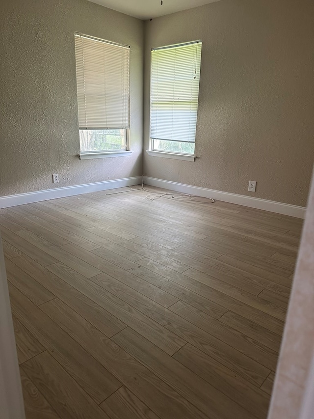 302 E Byrd St, Universal City, TX 78148 - spare room featuring wood finished floors, baseboards, and a textured wall