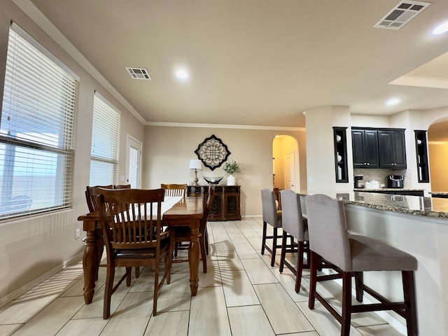 dining room with visible vents, arched walkways, and light tile patterned flooring