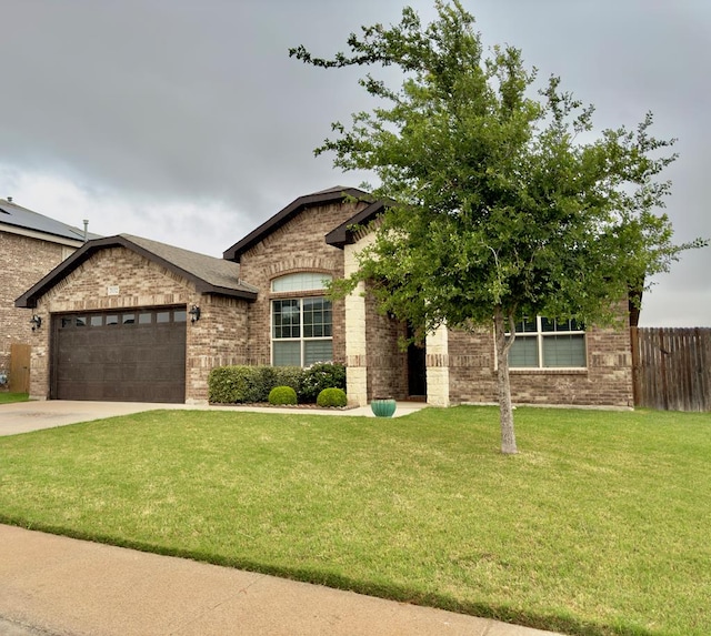 french country style house featuring fence, a front lawn, brick siding, a garage, and concrete driveway