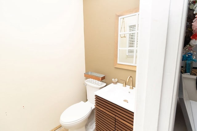 half bathroom with vanity and toilet