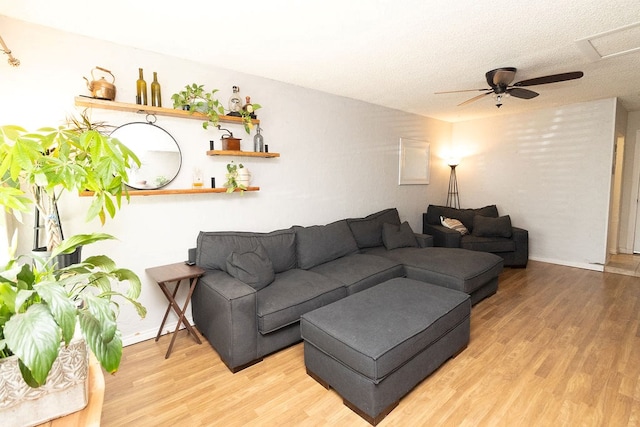living area with baseboards, a textured ceiling, ceiling fan, and wood finished floors