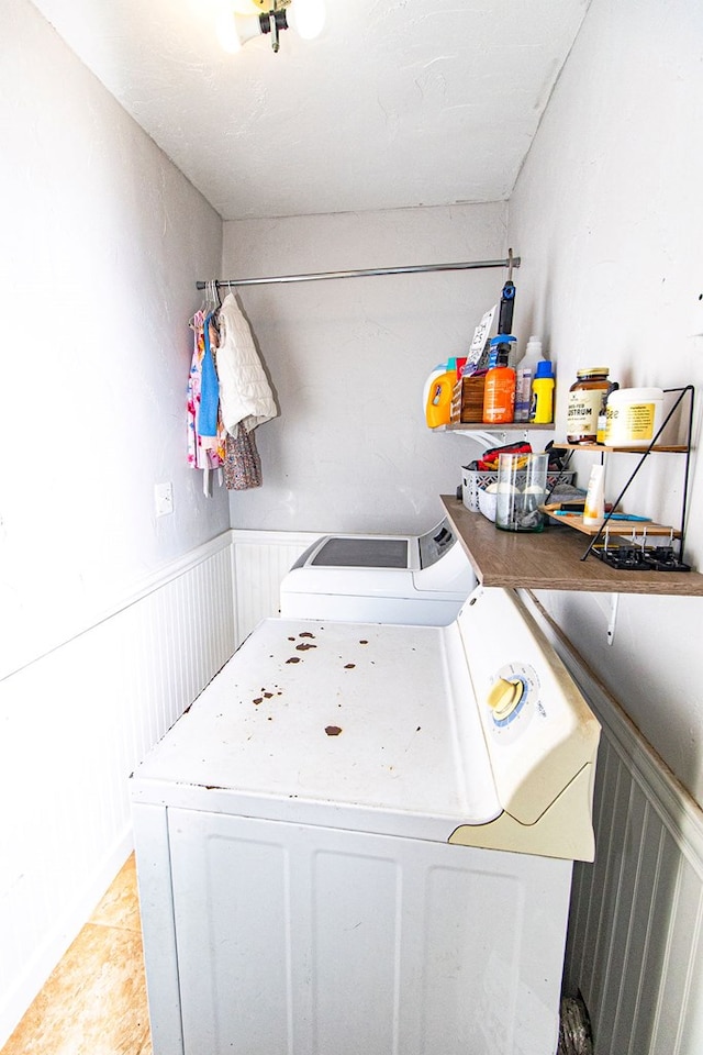 laundry room featuring wainscoting, laundry area, and washing machine and dryer