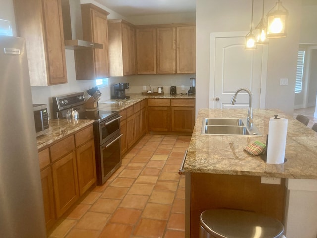 420 Santana Dr, Lajitas, TX 79852 - kitchen featuring appliances with stainless steel finishes, a sink, an island with sink, wall chimney range hood, and hanging light fixtures