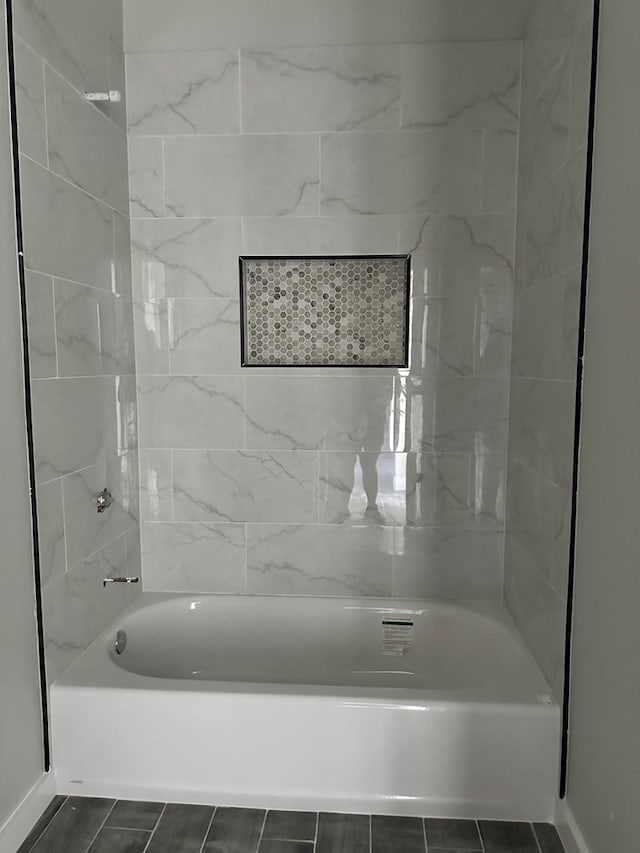 bathroom featuring shower / bath combination and baseboards