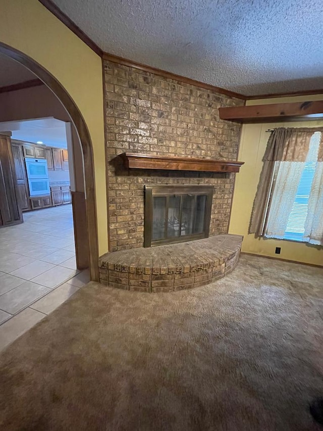 unfurnished living room featuring a textured ceiling, a fireplace, and light tile patterned floors