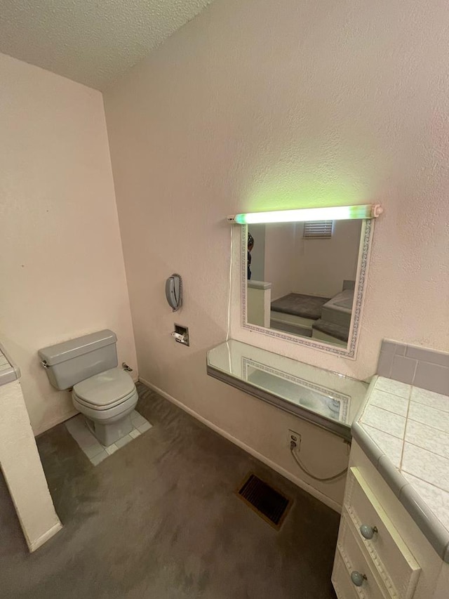 bathroom featuring toilet and a textured ceiling