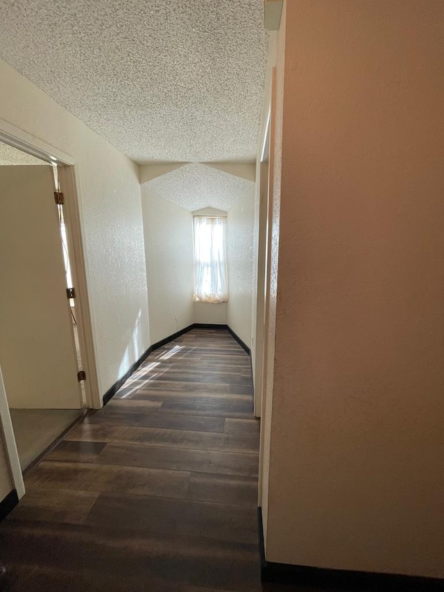 corridor featuring a textured ceiling and dark hardwood / wood-style floors