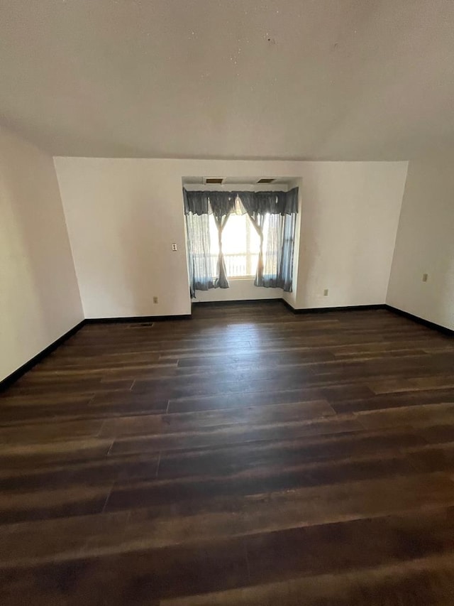 spare room featuring dark wood-type flooring