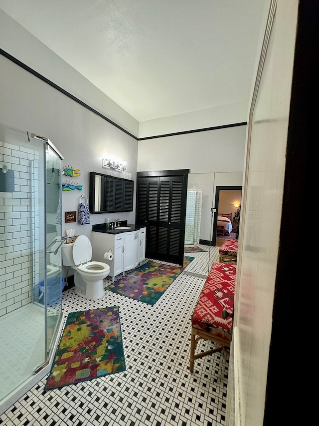 bathroom featuring tile patterned floors, vanity, toilet, and an enclosed shower