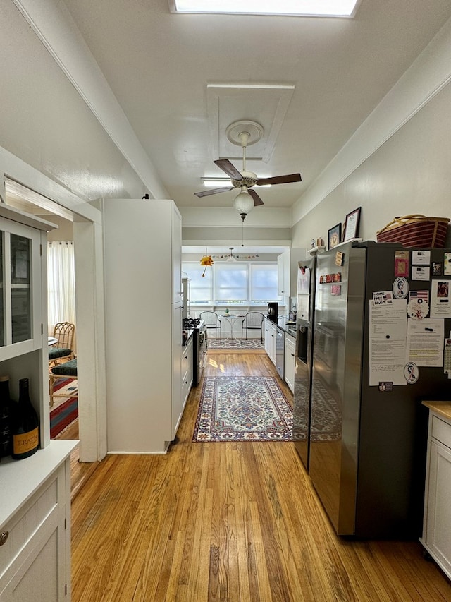 kitchen featuring white cabinets, ceiling fan, light hardwood / wood-style floors, and stainless steel refrigerator with ice dispenser