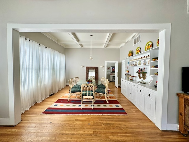 dining space featuring beamed ceiling, light hardwood / wood-style flooring, and coffered ceiling