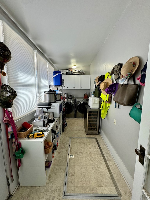 kitchen with washing machine and dryer, white cabinets, and wine cooler