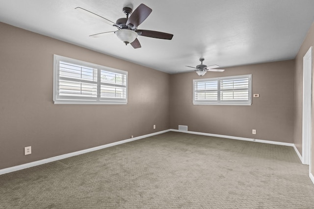 carpeted empty room featuring a ceiling fan, baseboards, and visible vents