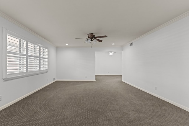 unfurnished room with visible vents, ornamental molding, baseboards, dark carpet, and a ceiling fan
