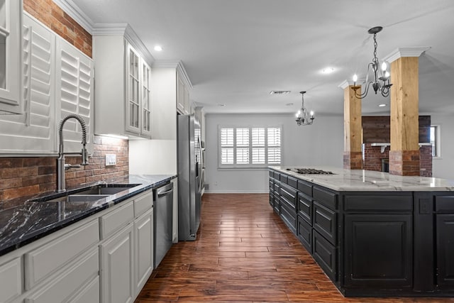 kitchen featuring a sink, white cabinets, an inviting chandelier, dark cabinetry, and stainless steel appliances