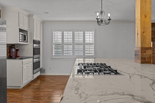 kitchen featuring crown molding, light stone counters, dark wood-style floors, stainless steel appliances, and white cabinetry