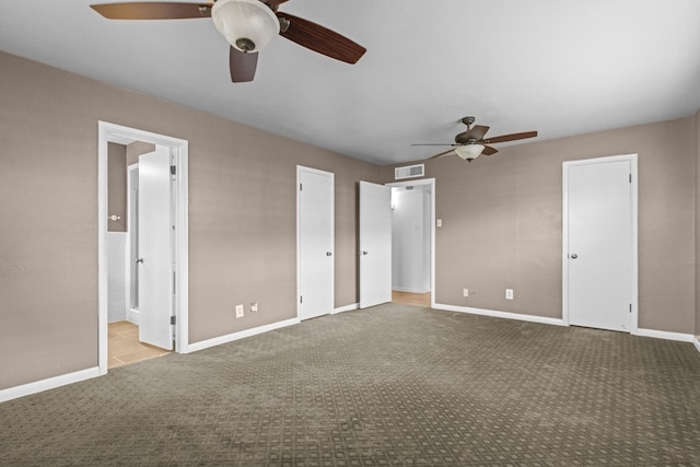 unfurnished bedroom with visible vents, carpet floors, baseboards, ceiling fan, and ensuite bath