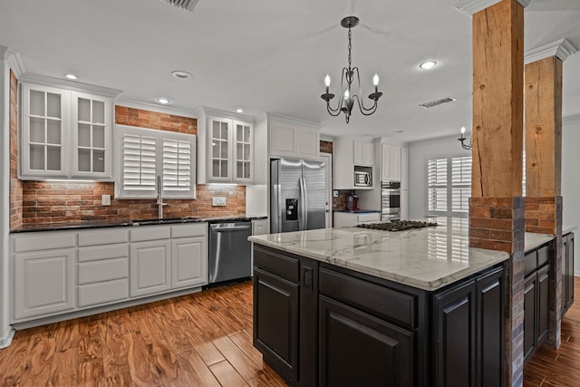 kitchen featuring dark cabinets, a sink, white cabinets, and stainless steel appliances