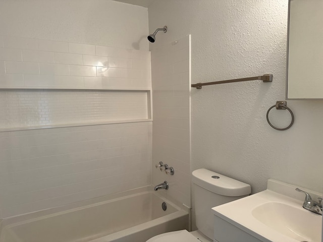 full bath featuring toilet, shower / bathtub combination, vanity, and a textured wall