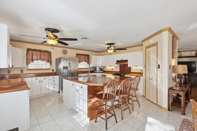 203 NE 8th St, Marathon, TX 79842 - kitchen featuring a ceiling fan, appliances with stainless steel finishes, light tile patterned floors, and ornamental molding