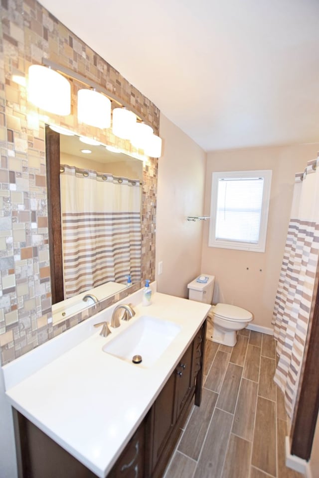 bathroom with backsplash, vanity, toilet, and tile walls