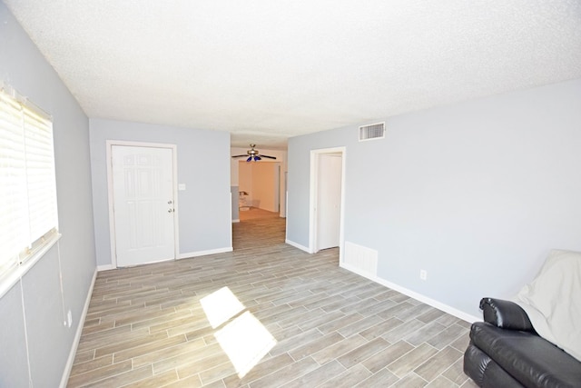 unfurnished living room featuring light hardwood / wood-style floors and a textured ceiling