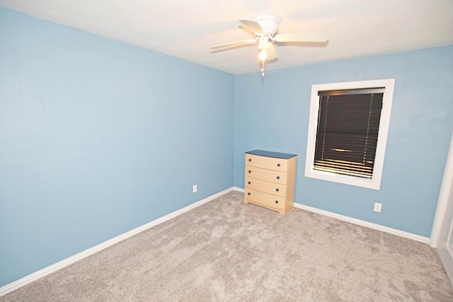 unfurnished room with light colored carpet and ceiling fan