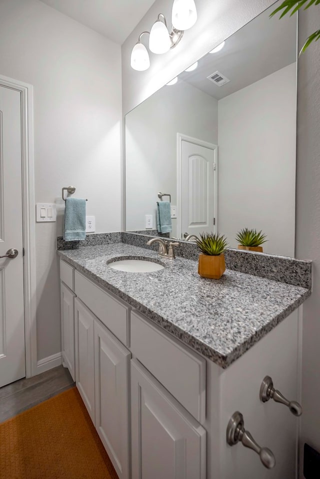 8430 E County Rd 114, Midland, TX 79706 - bathroom with vanity, wood finished floors, and baseboards