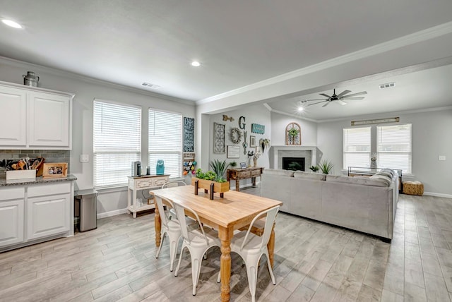 8430 E County Rd 114, Midland, TX 79706 - dining space featuring a ceiling fan, crown molding, baseboards, light wood-style flooring, and healthy amount of natural light