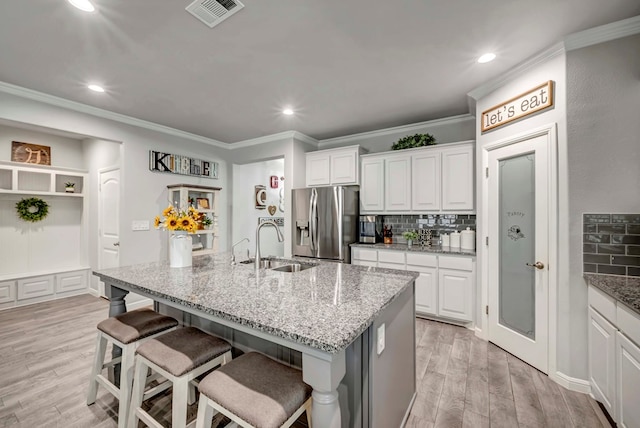 8430 E County Rd 114, Midland, TX 79706 - kitchen featuring stainless steel fridge, a sink, tasteful backsplash, light wood-style floors, and crown molding