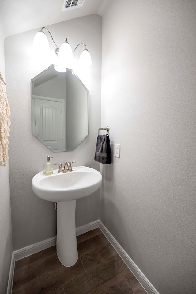 8430 E County Rd 114, Midland, TX 79706 - bathroom featuring wood finished floors, baseboards, and a sink