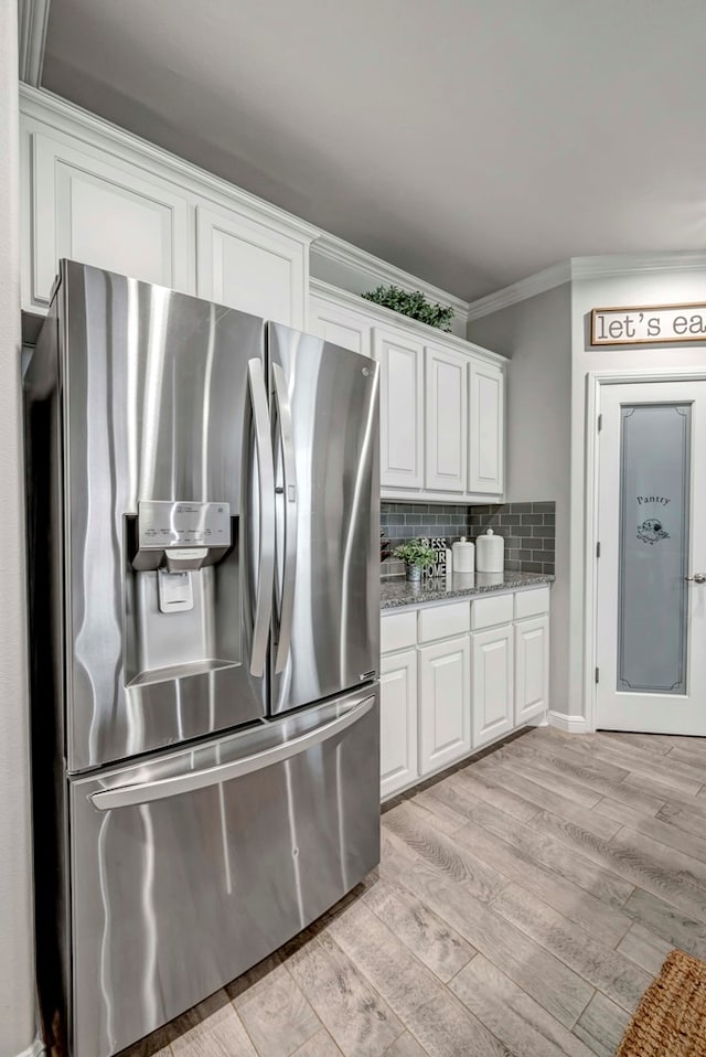 8430 E County Rd 114, Midland, TX 79706 - kitchen with stainless steel refrigerator with ice dispenser, crown molding, white cabinetry, light wood-type flooring, and tasteful backsplash